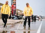 Сотрудники автодрома в Индианаполисе разгоняют воду на пит-лейн ручным способом, фото пресс-службы IndyCar