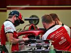Кими Райкконен (слева) помогает механикам Alfa Romeo работать с его машиной