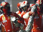 Механики Ferrari возвращают в боксы заправочный шланг, вырванный Фелипе Массой...