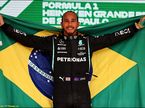 Льюис Хэмилтон с бразильским флагом на подиуме в Сан-Паулу