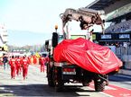 Машину Ferrari возвращают в боксы команды после аварии на тестах в Барселоне