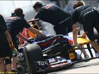 Механики Red Bull Racing закатывают в боксы машину Себастьяна Феттеля